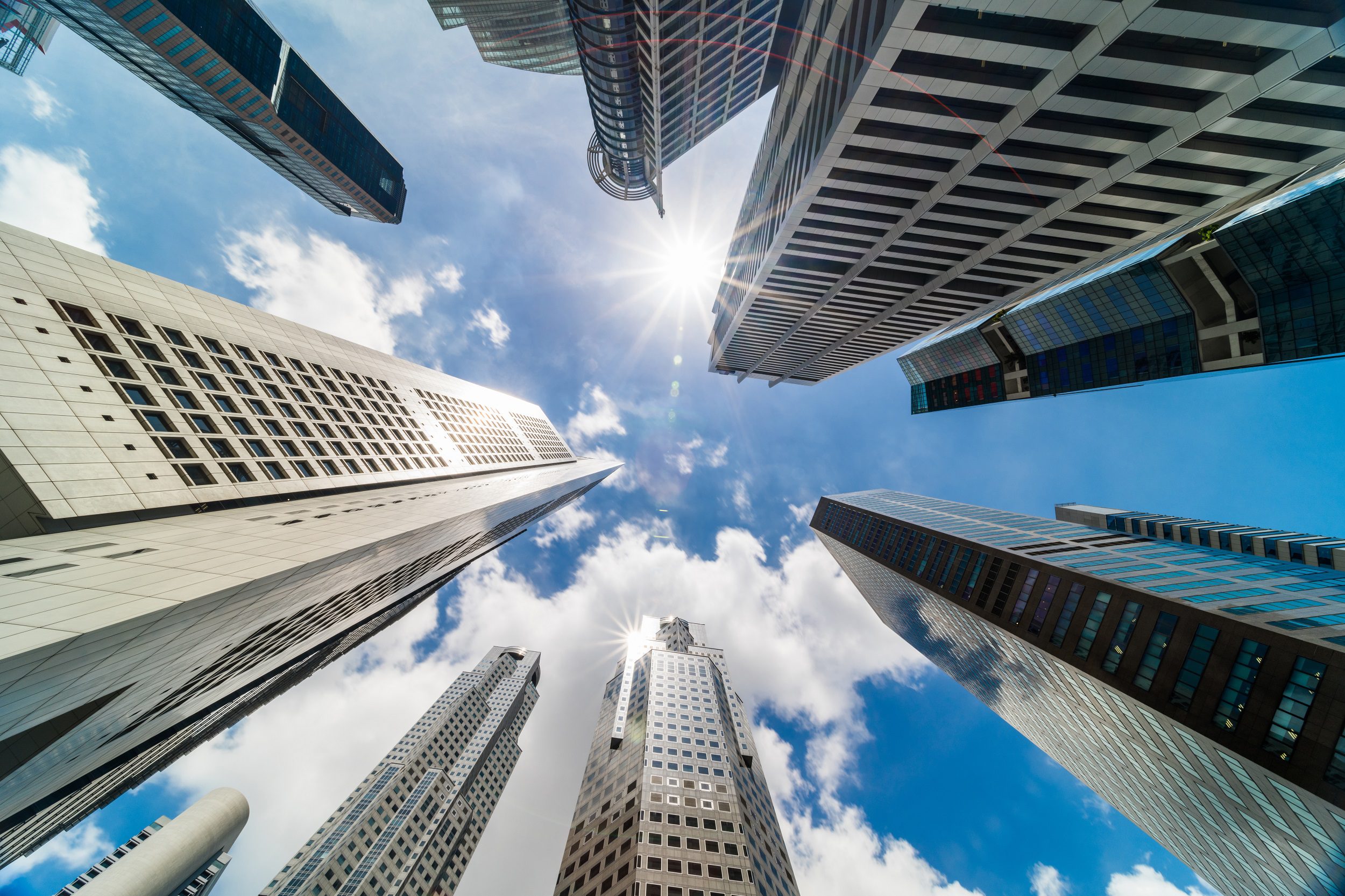Skyscrapers towering against a blue sky with scattered clouds.