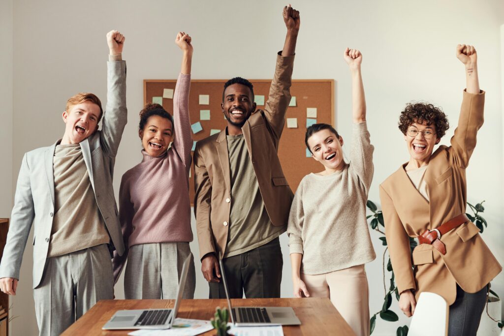 A diverse group of coworkers celebrating success in an office.